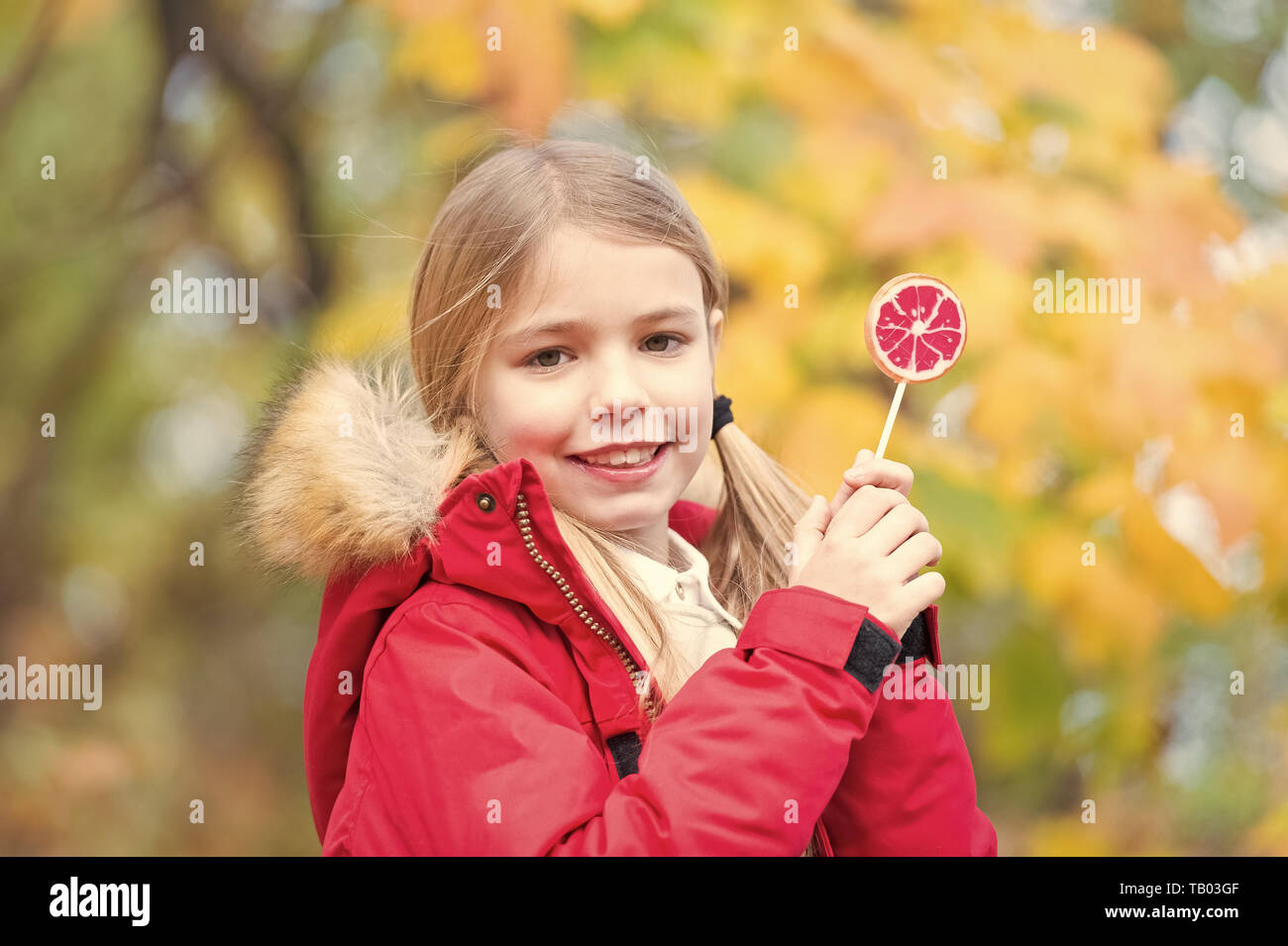 Gerne kleine Mädchen mit Süßigkeiten im Herbst Wald. Nur ein kleines Mädchen. Candy Girl. Glückliche Kindheit. Herbst kam. Stockfoto