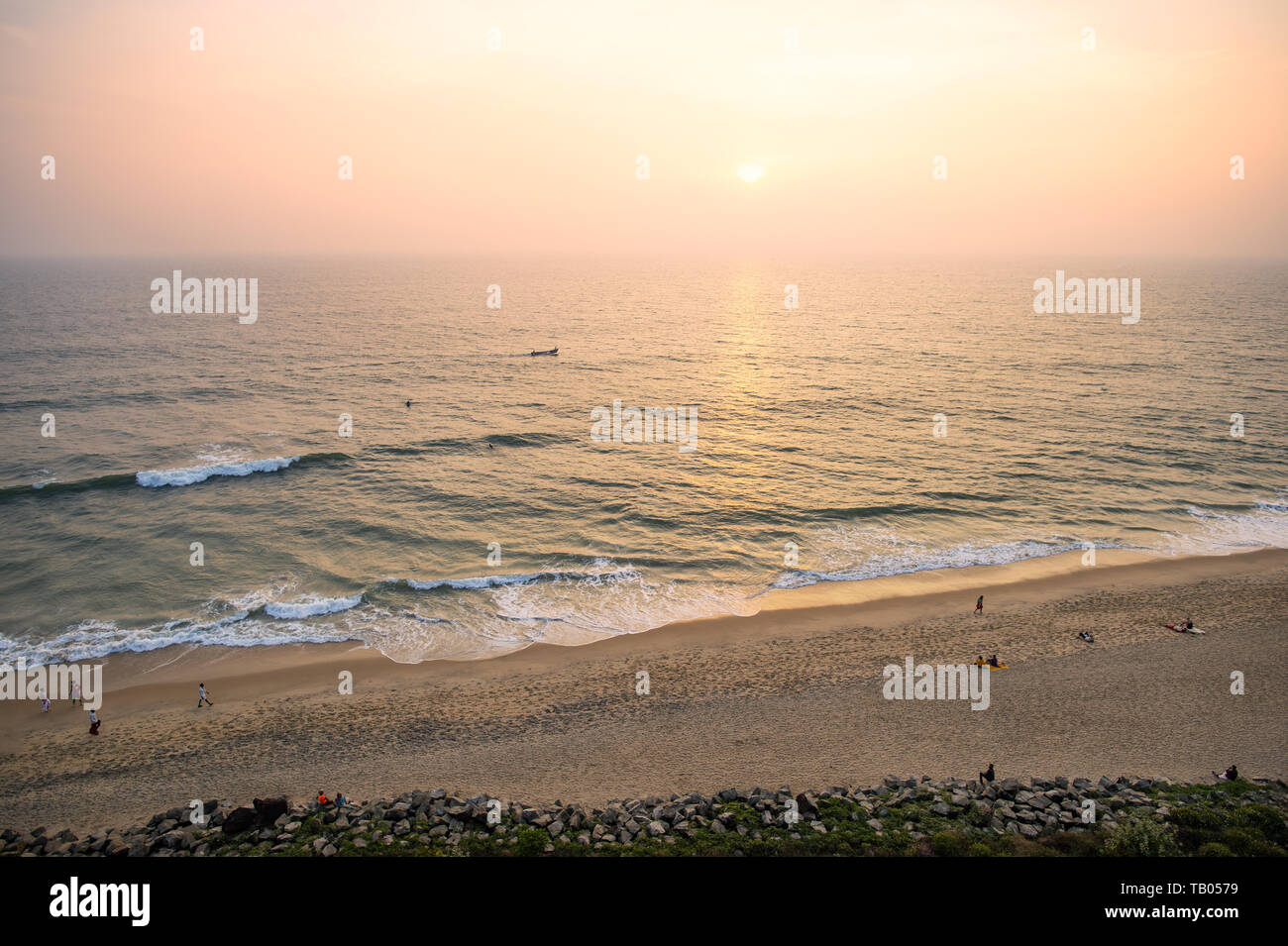 Ansicht von oben, einen atemberaubenden Blick auf einen wunderschönen tropischen Strand mit Menschen Sonnenbaden und genießen einen wunderschönen Sonnenuntergang. Cochin, Kerala, Indien. Stockfoto