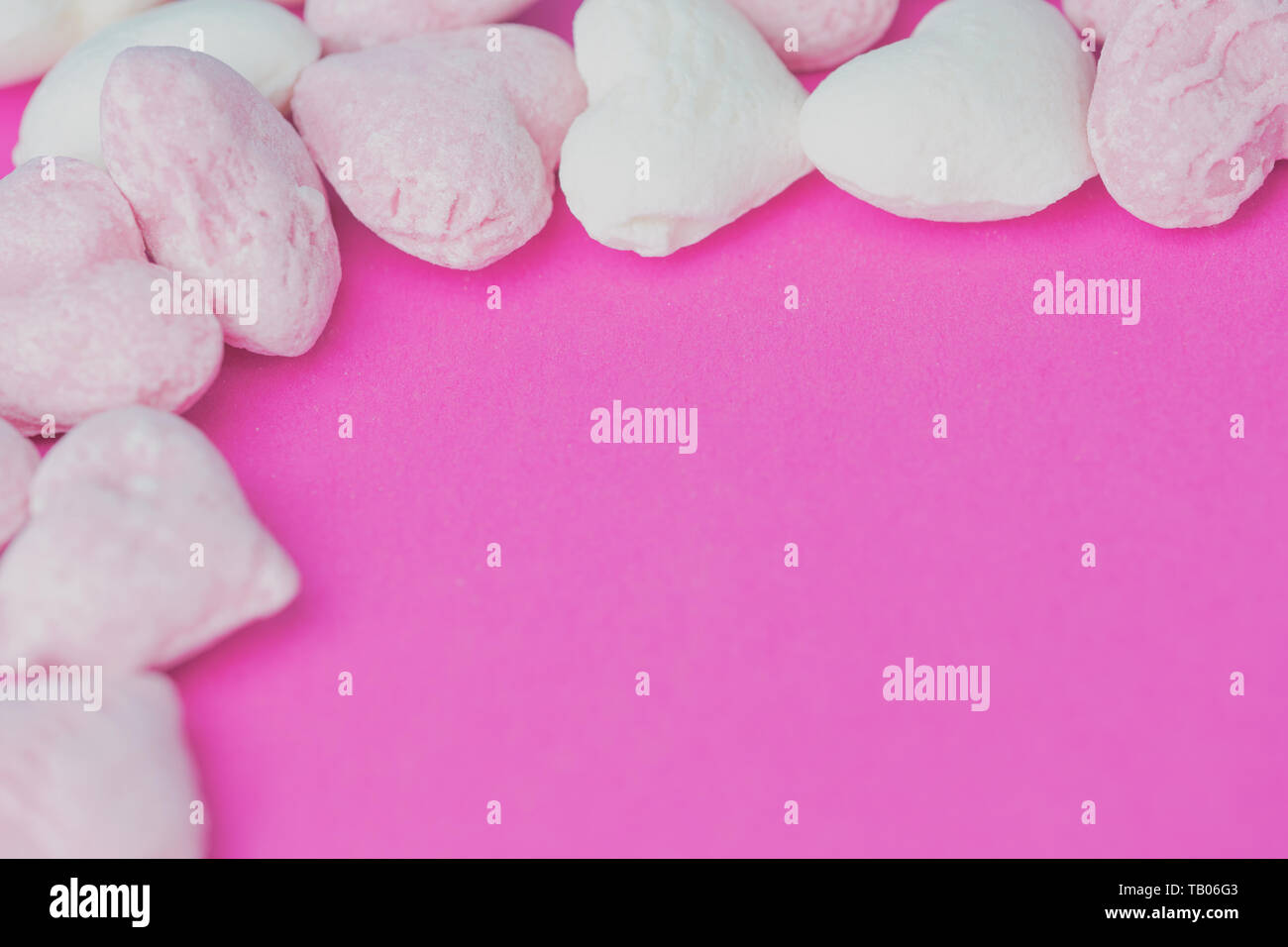 Herzförmigen Rosa und Weiß harte Süßigkeiten auf einem rosa Hintergrund mit Kopie Raum Stockfoto