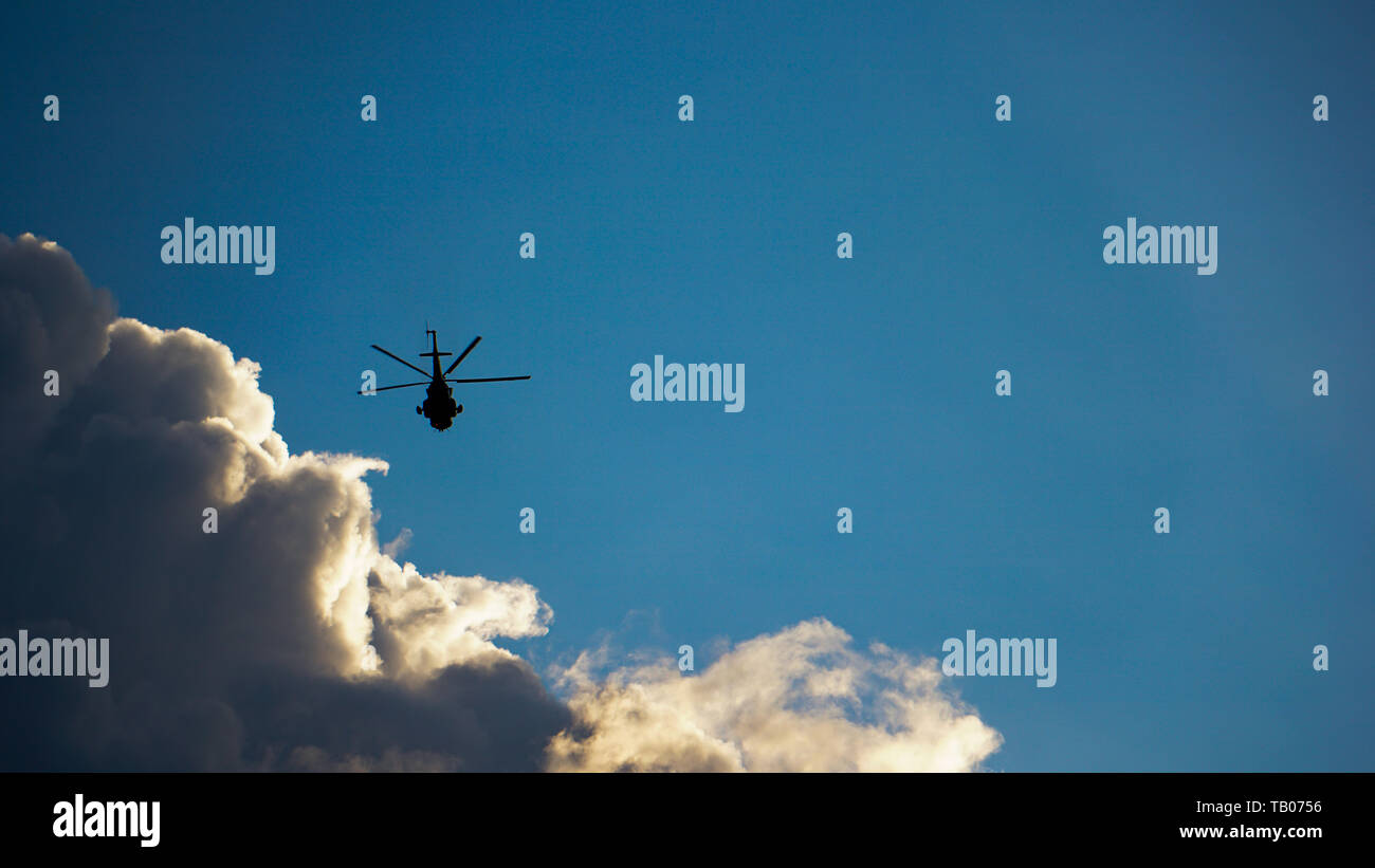 Silhouette von Big Heli im Flug gegen die drastischen Himmel und Wolken Stockfoto