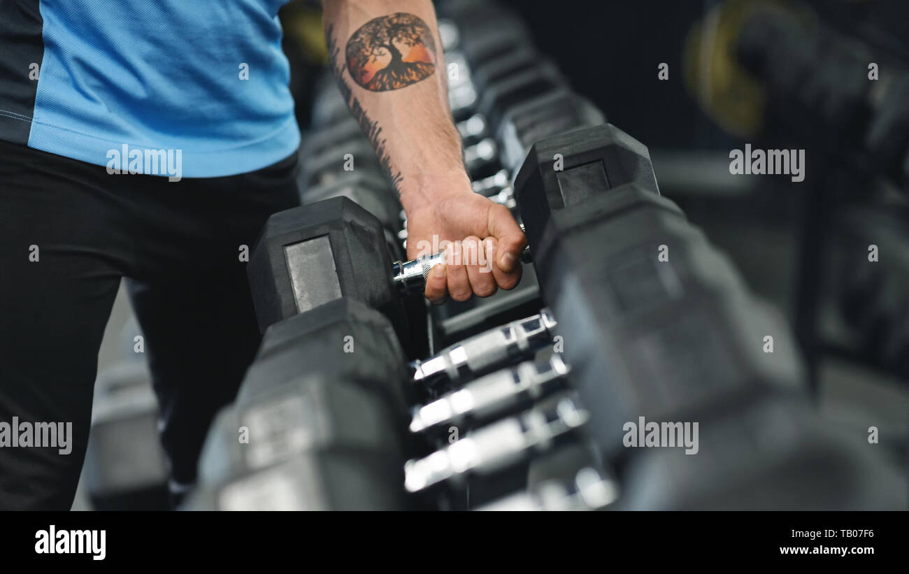 Muskulöse Männer arm Herauf schwere Hantel vom Geräteträger Stockfoto