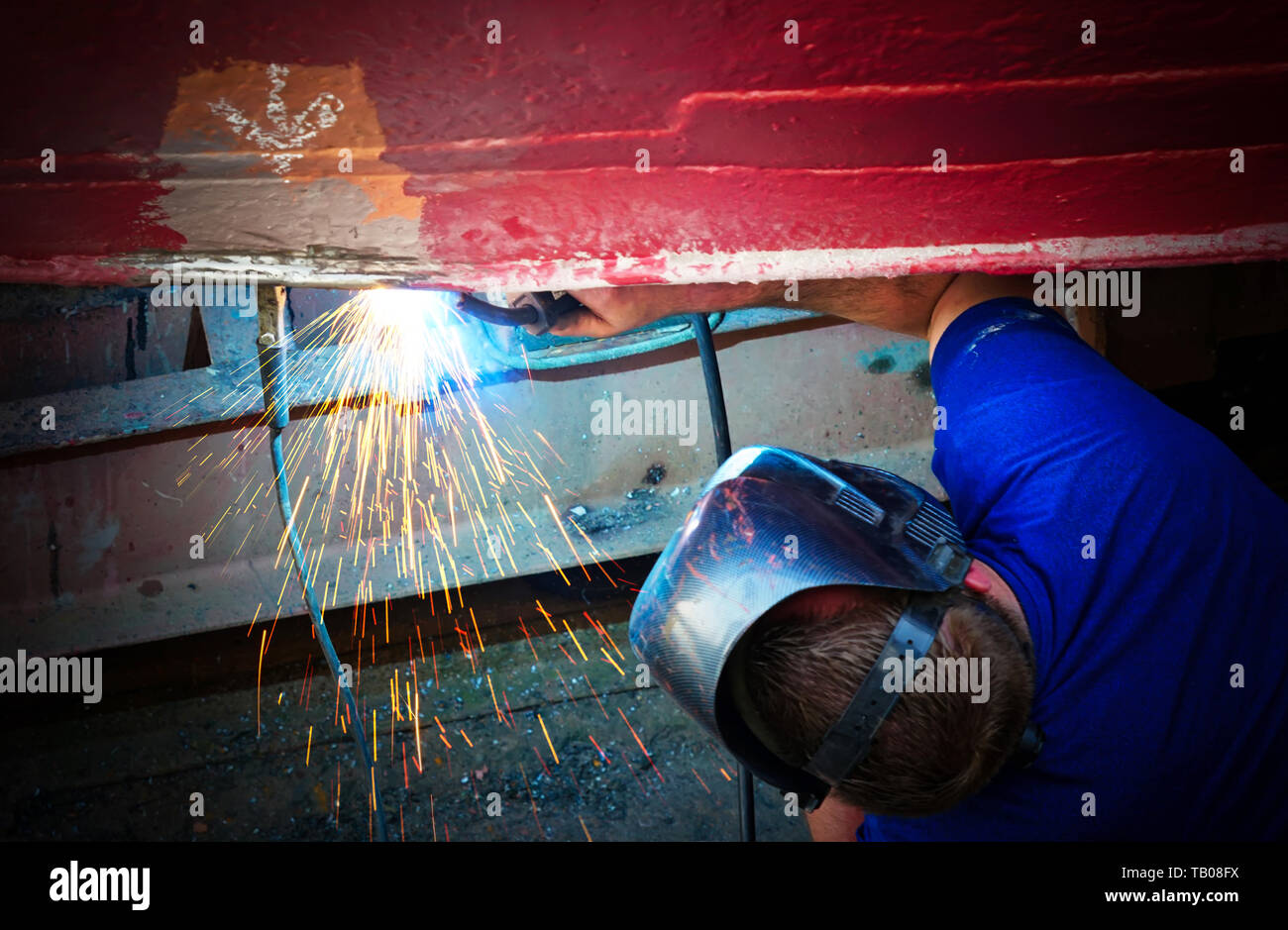 Junger Mann Schweißen etwas auf dem Boot Stockfoto