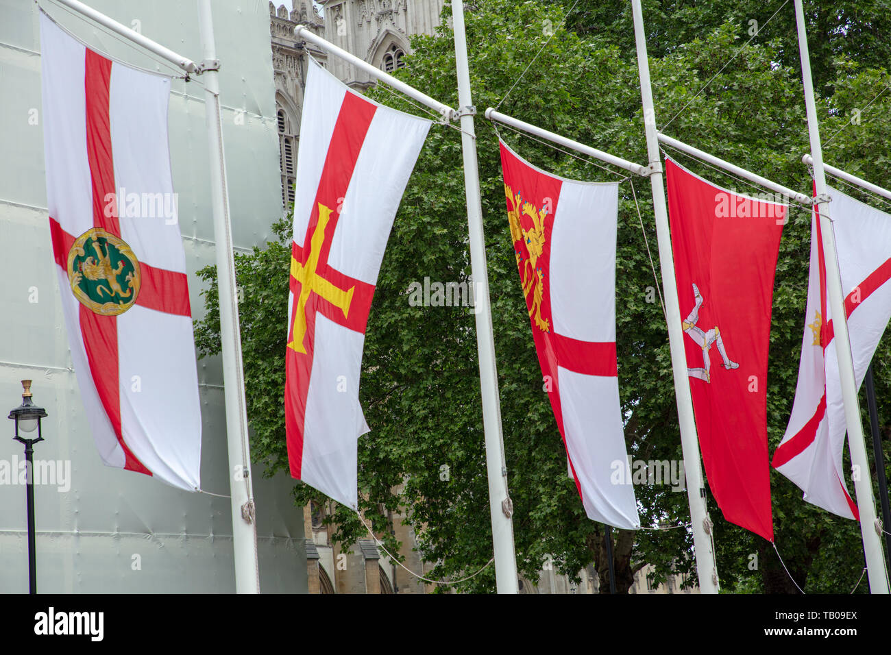 Flaggen der Britischen Krone Abhängigkeiten fliegen in den Wind. Parliament Square, London, UK in der Feier von Crown Dependencies und überseeischen Gebiete. Stockfoto