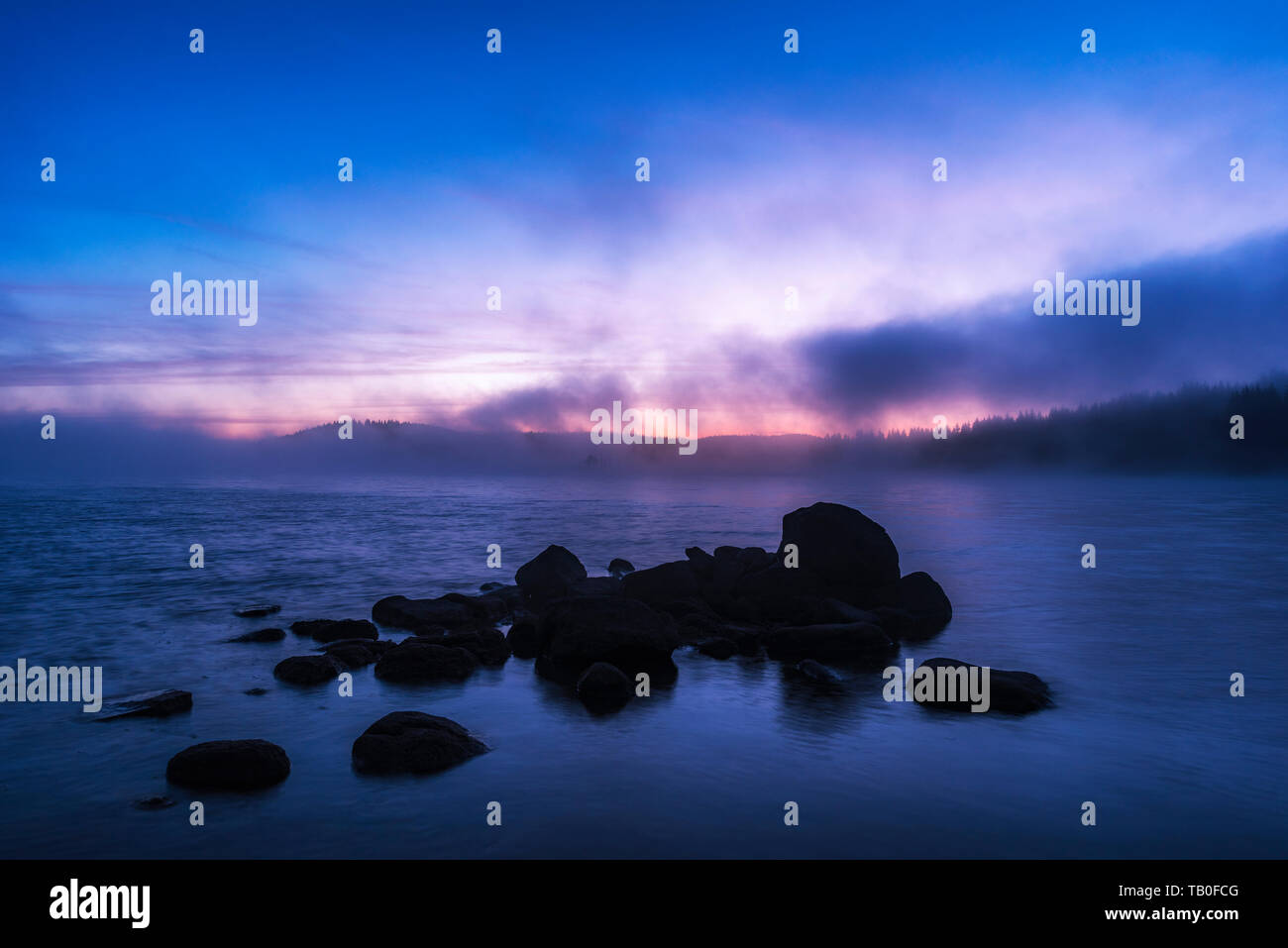 Atemberaubende Bild von den nebligen See. Dramatischer Sonnenaufgang Szene. Stockfoto