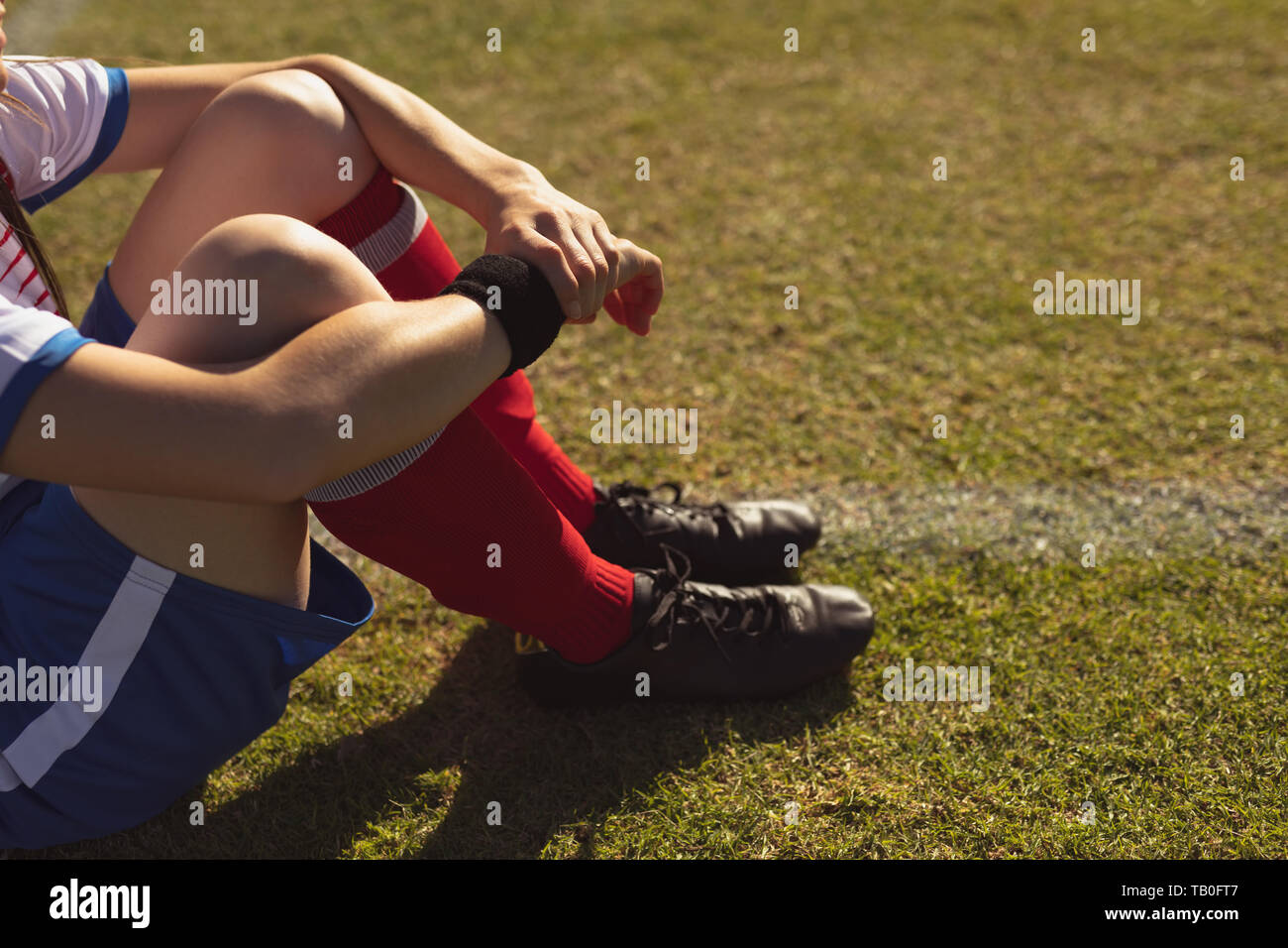 Weibliche Fußball-Spieler am Sportplatz sitzen Stockfoto