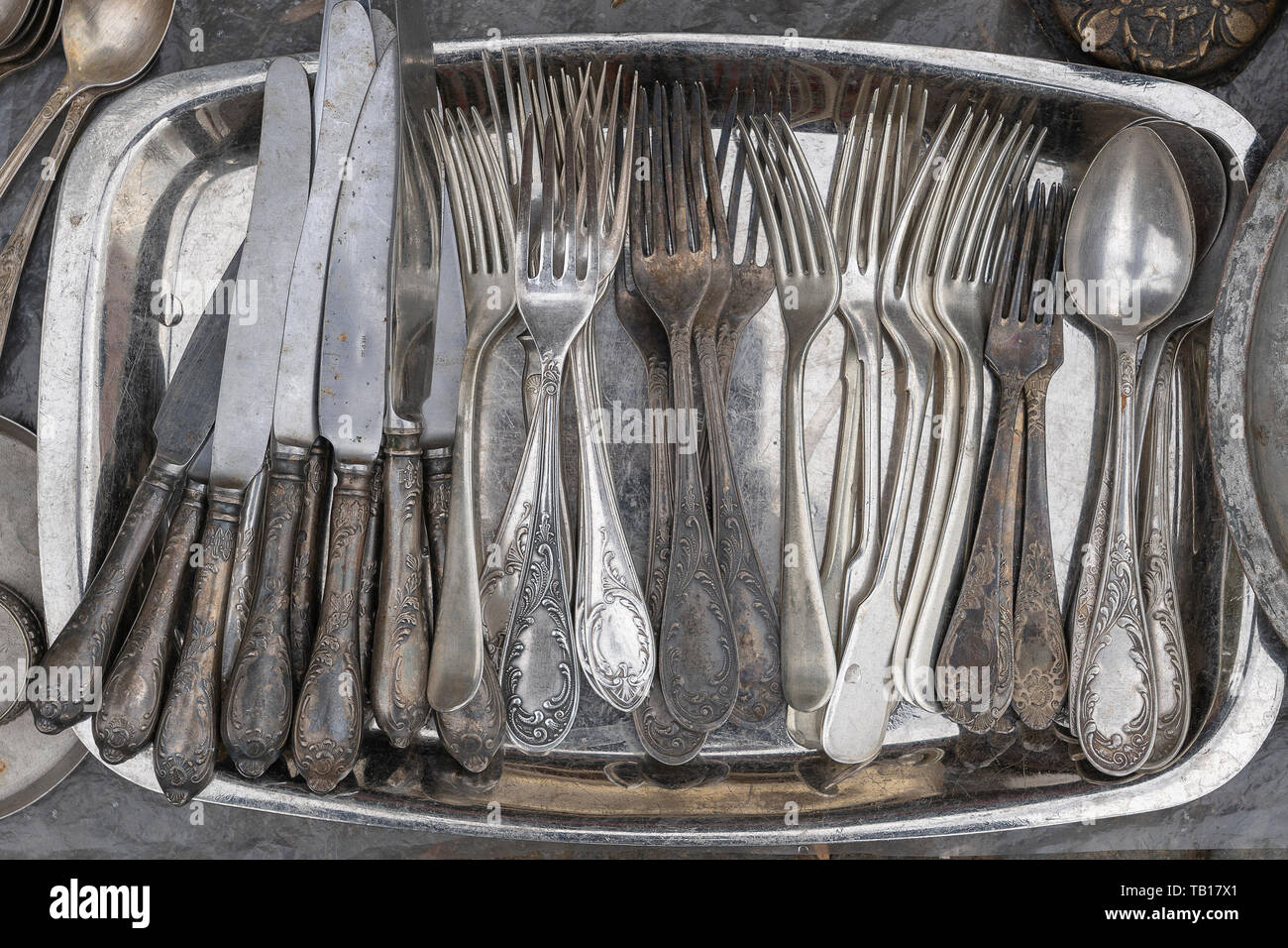 Alte Löffel, Gabeln, Messer an einem Metallauflagefach und auf einem Flohmarkt verkauft, Ansicht von oben, in der Nähe Stockfoto