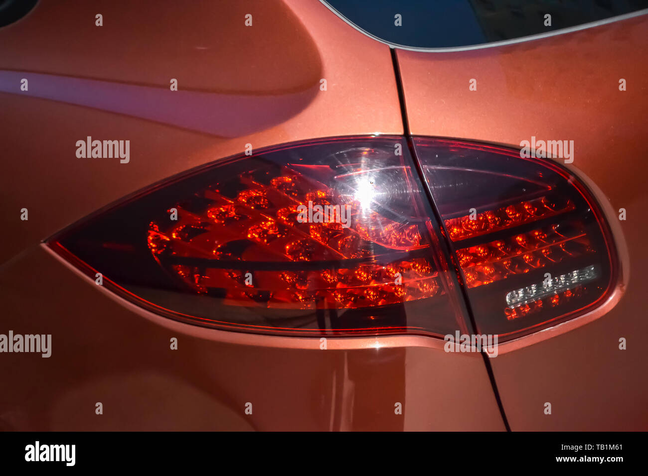 Nowosibirsk, Russland - 05.29.2019: Hinten schlußlicht Blick auf Porsche Cayenne 958 2013 in brauner Farbe nach der Reinigung vor dem Verkauf an einem sonnigen Sommertag mit Stockfoto