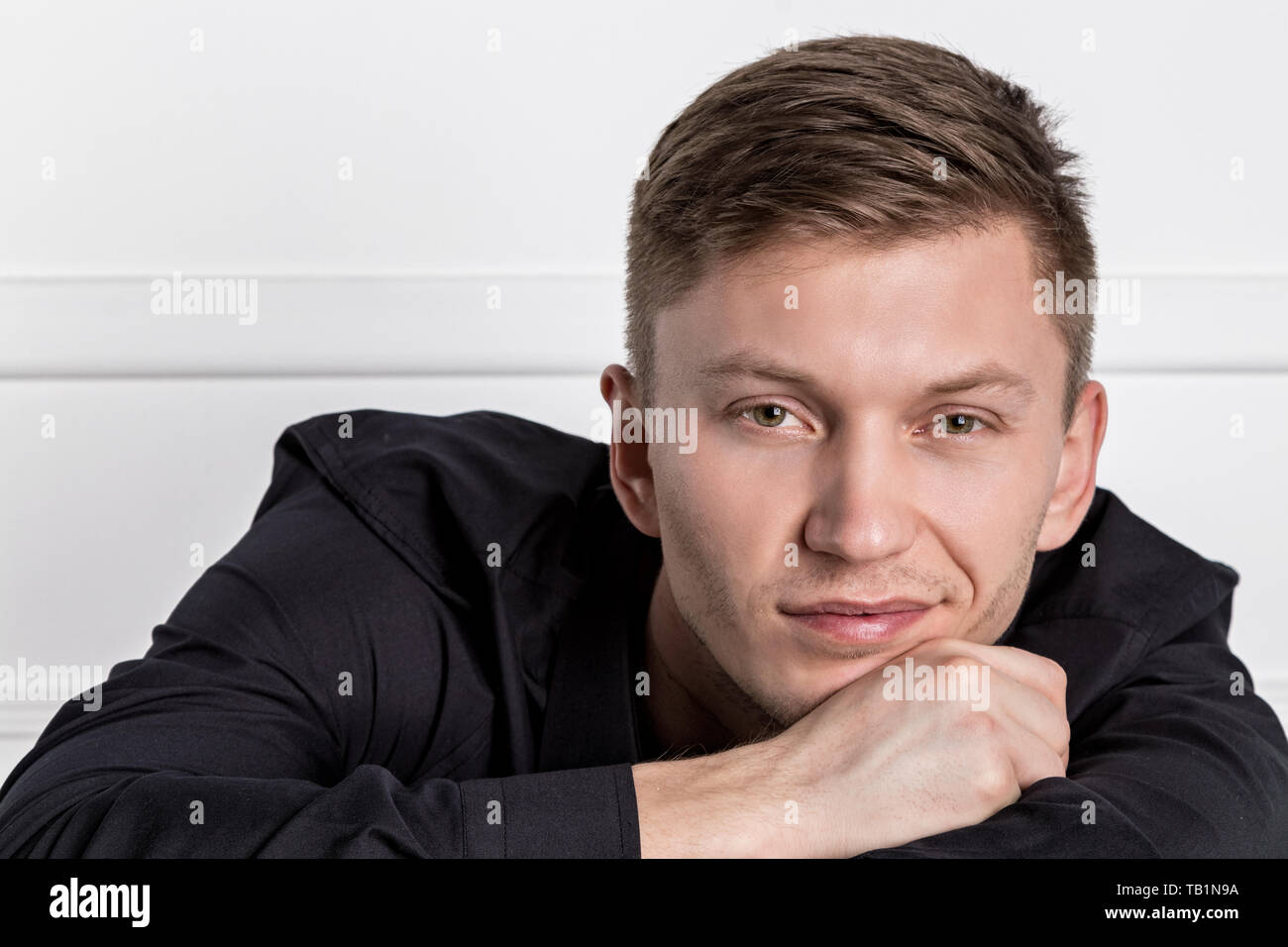 Nachdenklich jungen gutaussehenden Mann auf dem Stuhl Stockfoto