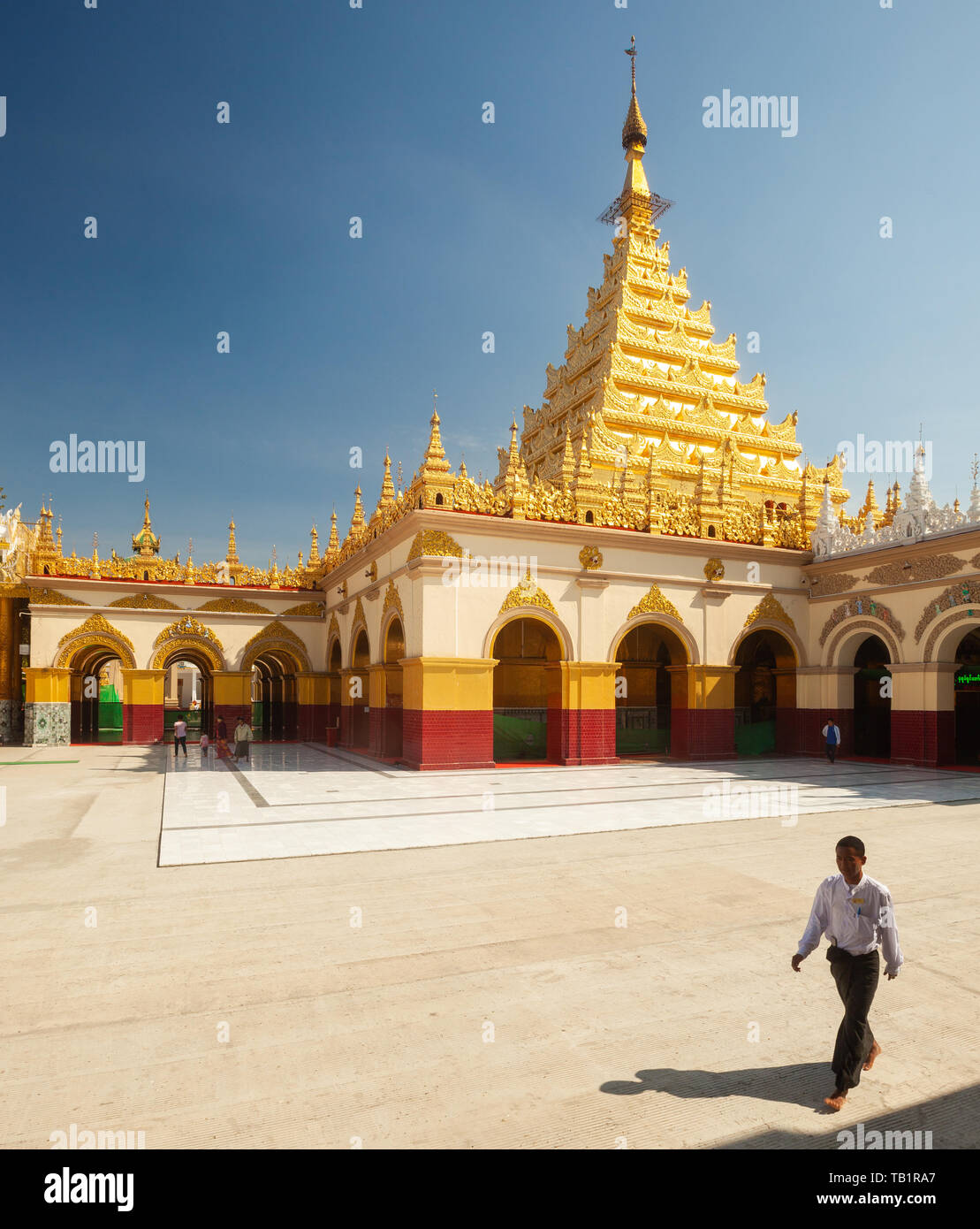 Mann Spaziergänge durch die Goldene Pagode und Innenhof auf Mahamuni Paya Tempels, Mandalay, Myanmar Stockfoto