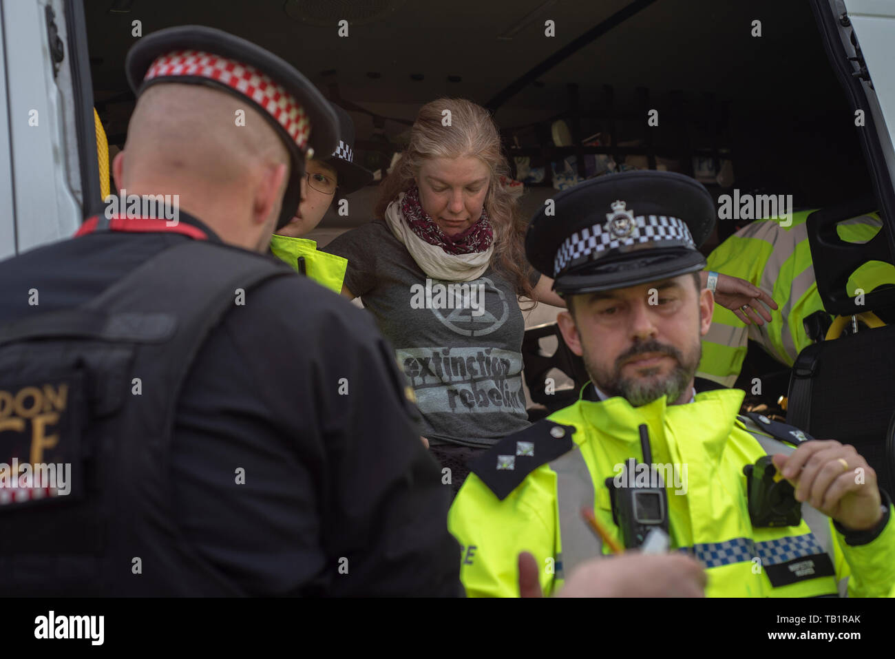 Dame/Frau extinctiion Rebellion Demonstrant, verhaftet und in einen Polizeiwagen, London gesucht, Klima Demonstrant Stockfoto