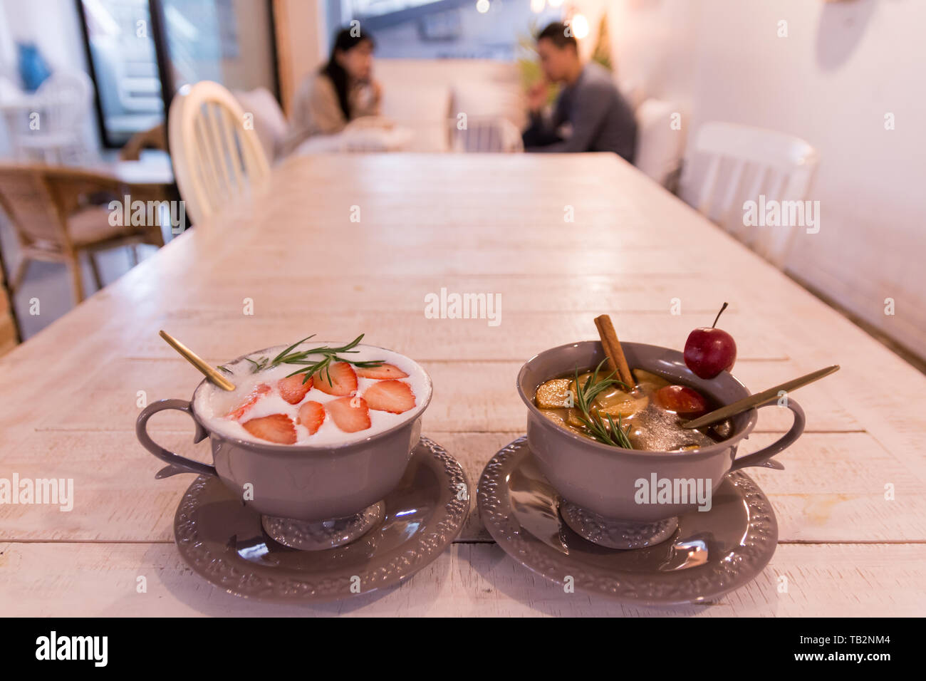 Obst aromatisierte Tee auf dem Holztisch mit unscharfen Paar im Hintergrund Stockfoto