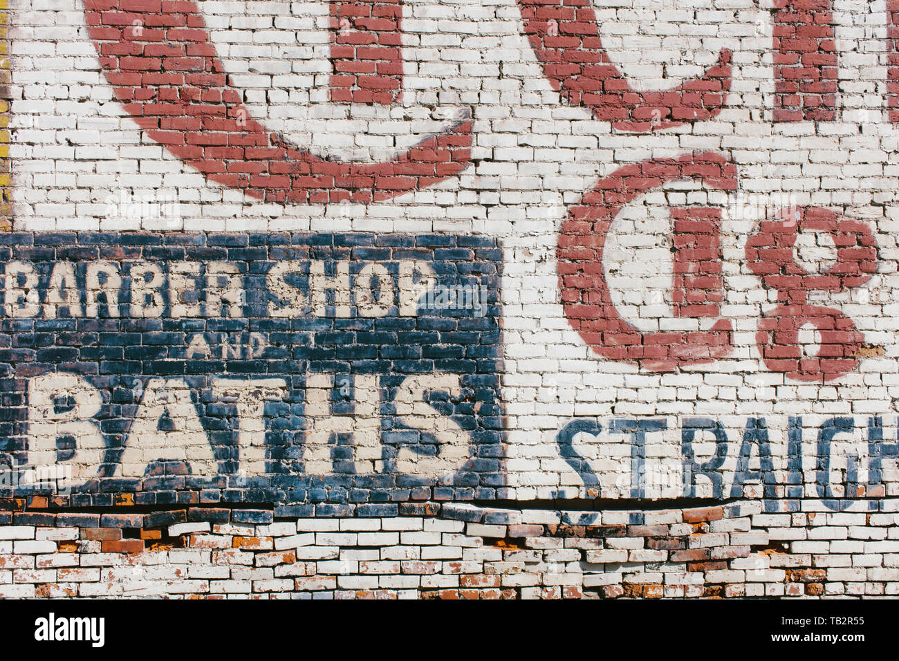 "Friseur & Bäder' Zeichen auf alten alten Ziegel Wand gemalt Stockfoto