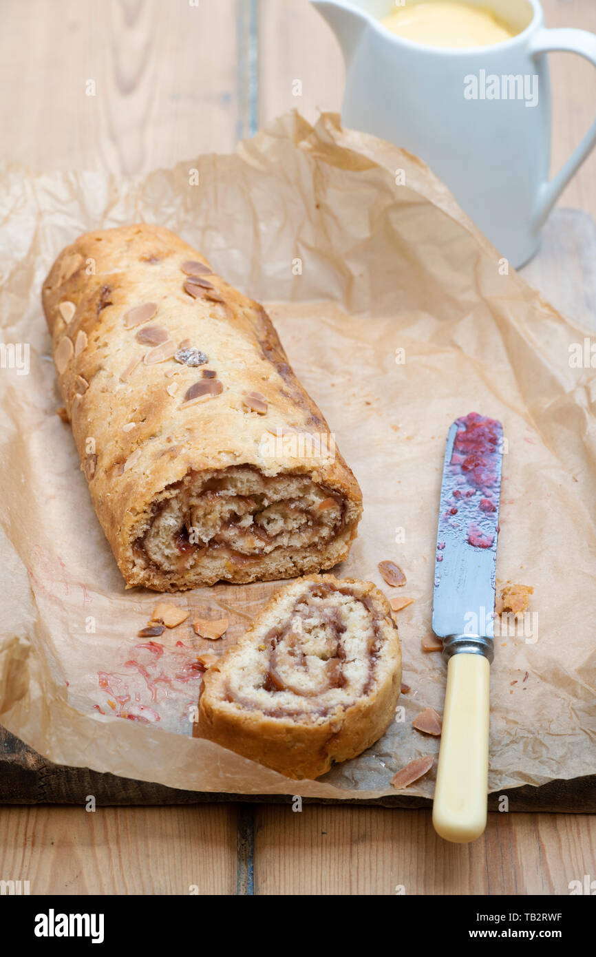 Hausgemachte Marmelade Roly Poly mit einem Krug Vanillesauce Stockfoto