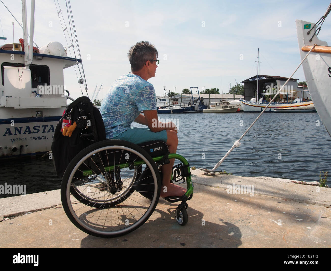 Behinderte Frau im Rollstuhl genießt die Aussicht auf die anclote River von Sponge Docks in Tarpon Springs, Florida, USA, 9. Mai 2019, © katharine Andr Stockfoto