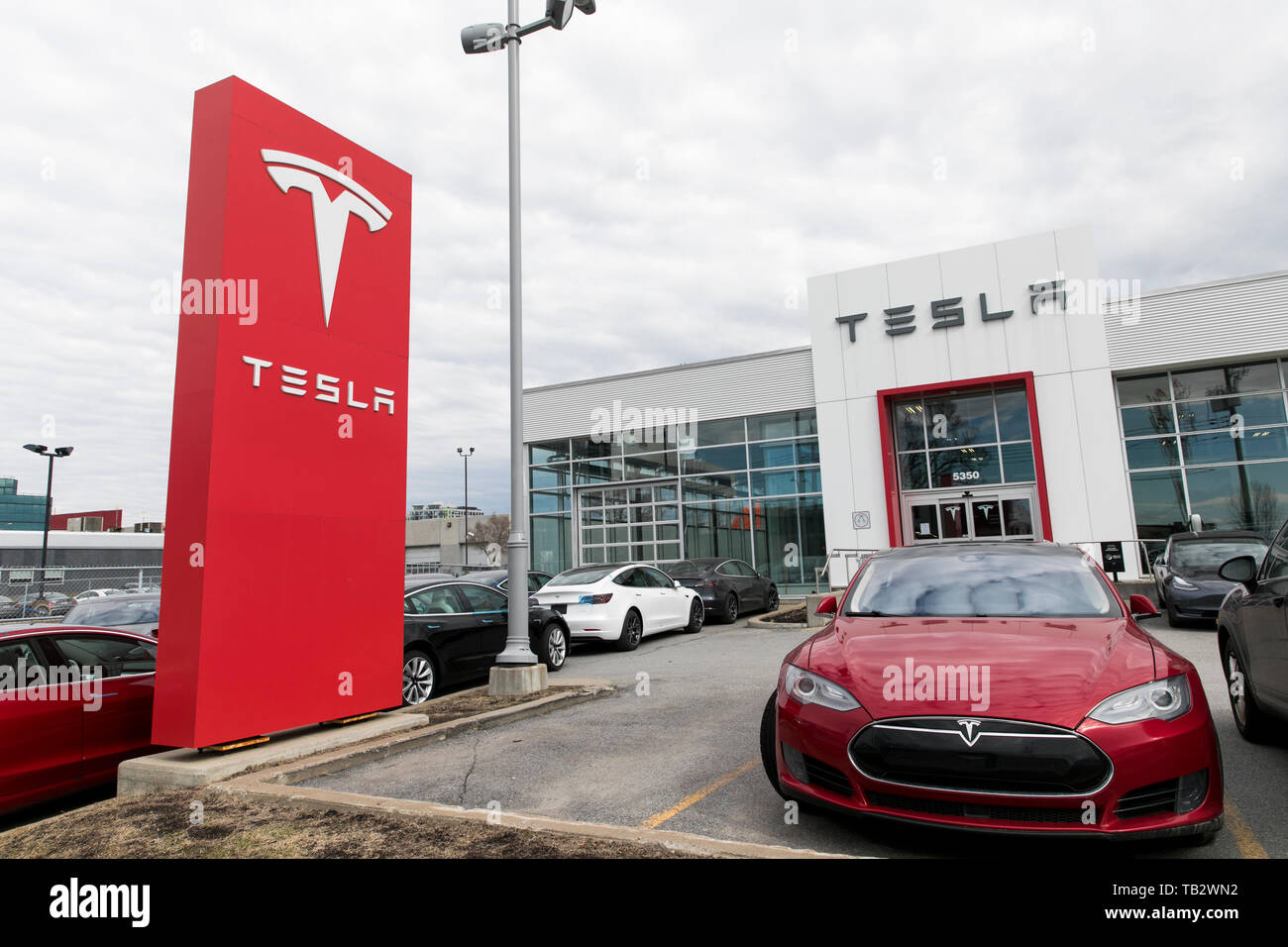 Ein logo Zeichen außerhalb eines Tesla Autohaus mit Modell 3 und Modell S Autos auf dem Parkplatz in Montreal, Quebec, Kanada, am 21. April 2019. Stockfoto