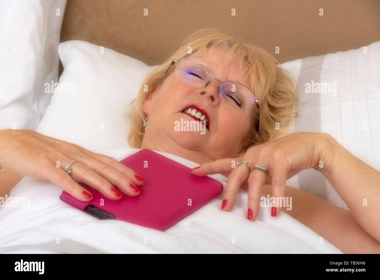 Portsmouth, England, Großbritannien 2019. Eine elederly Frau im Bett mit einem ipad Stockfoto