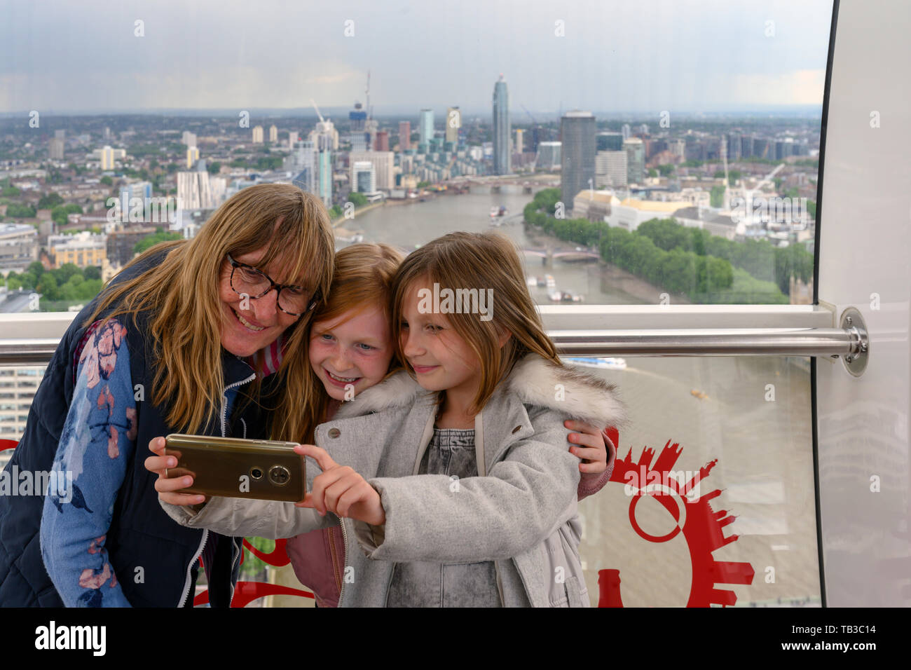 Großmutter teilen einer selfie mit zwei Enkelkinder, (Mädchen im Alter von 8 und 6 Jahren), während auf dem London Eye, London, England, UK. Stockfoto