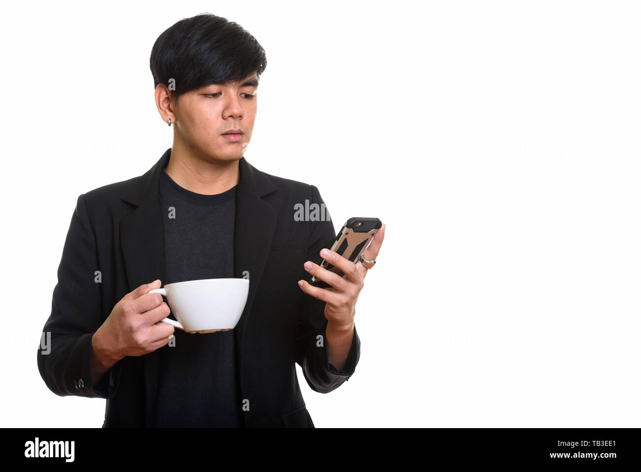 Studio shot cool aussehenden asiatischer Mann mit Handy während Stockfoto