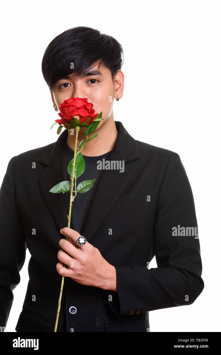 Studio shot cool aussehenden asiatischer Mann riechen rote Rosen Stockfoto