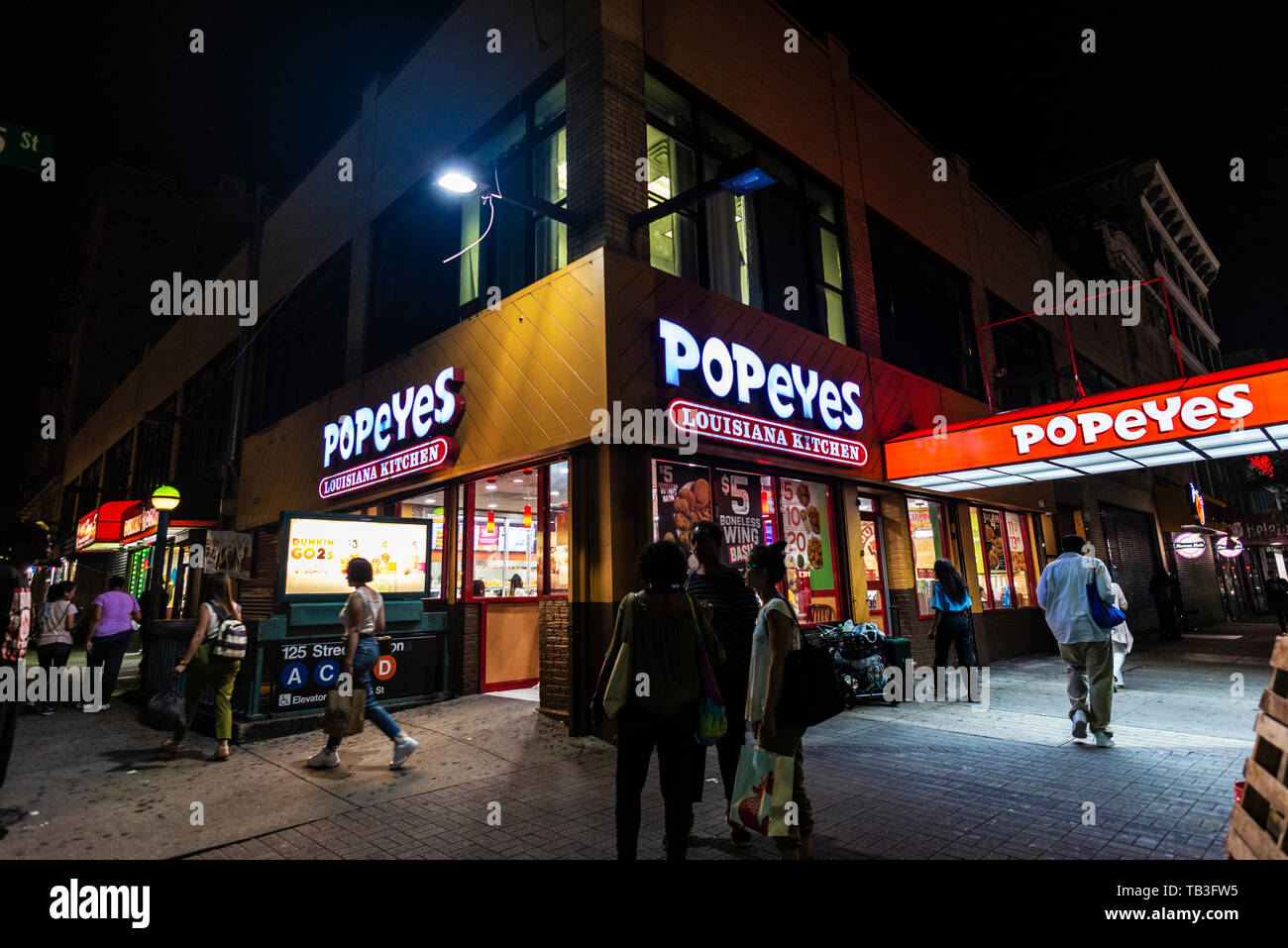 New York City, USA - 31. Juli 2018: Popeyes Restaurant bei Nacht mit Menschen in Harlem, Manhattan, New York City, USA Stockfoto