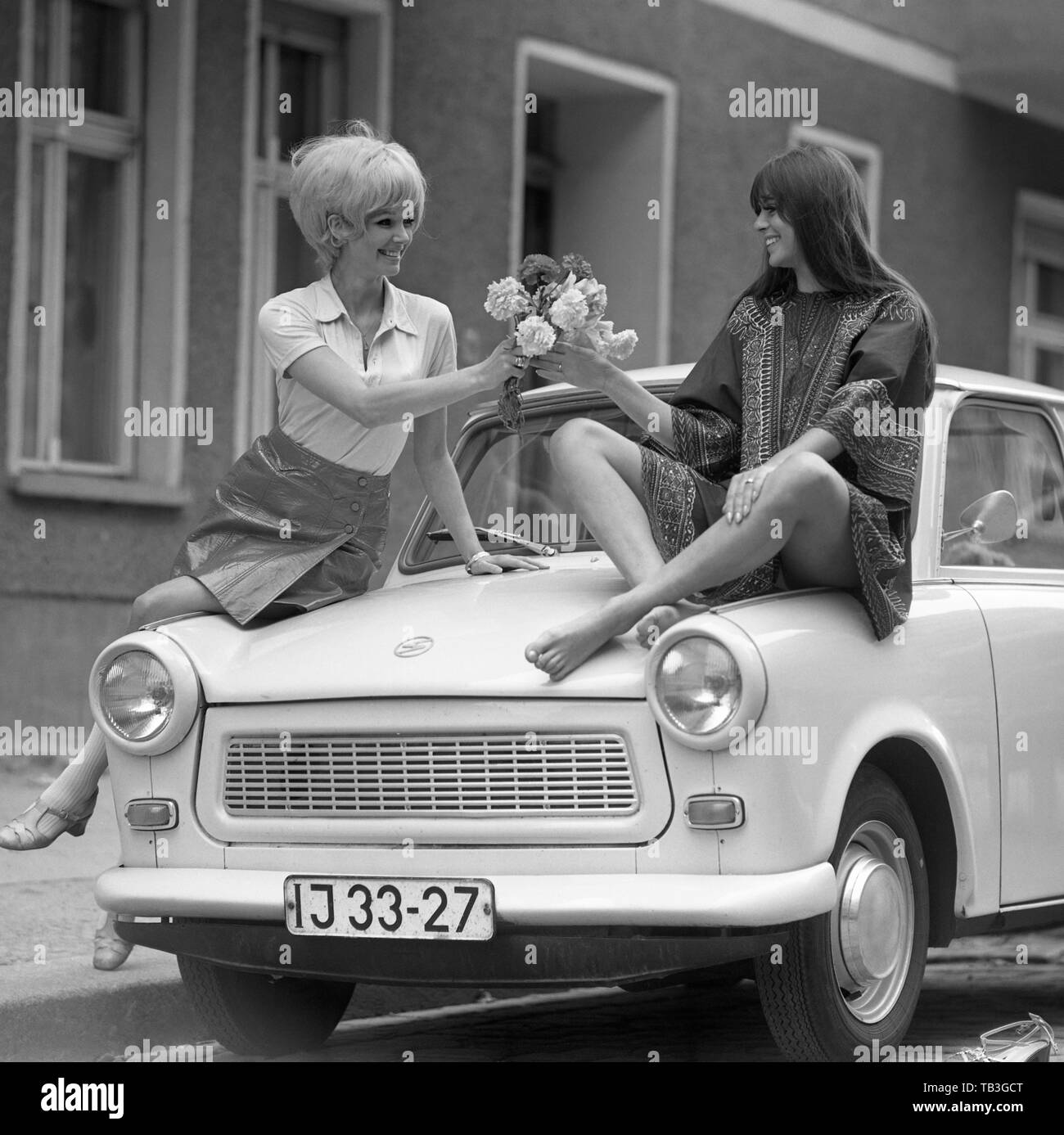 07.07.1971, Berlin, Berlin, DDR-Fashion Foto, junge Frau Hände Blumen zu ihrem Freund auf einem Trabant sitzen. 00 S 710707 D005 CAROEX.JPG [MODEL RELEASE: Stockfoto