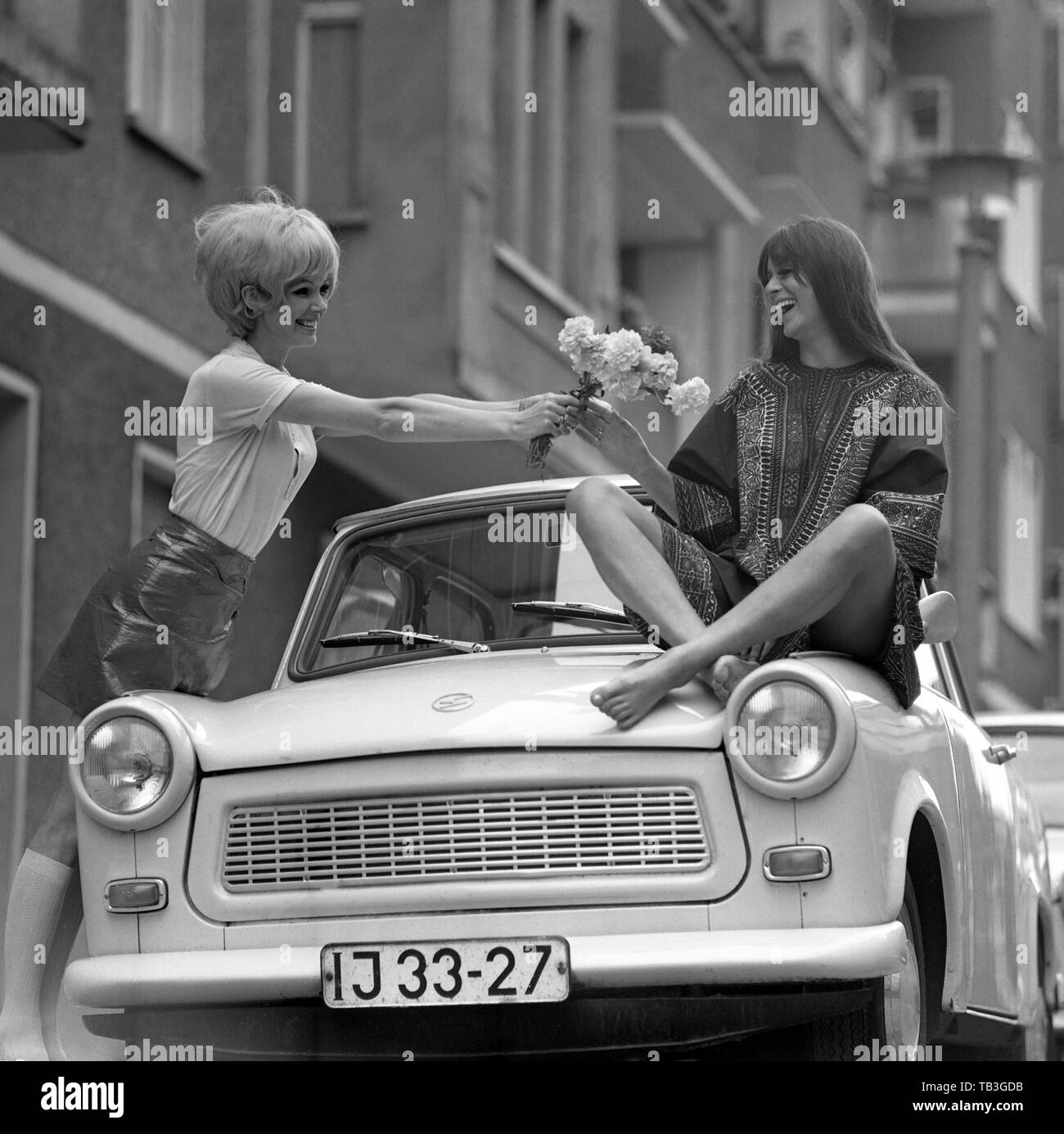 07.07.1971, Berlin, Berlin, DDR-Fashion Foto, junge Frau Hände Blumen zu ihrem Freund auf einem Trabant sitzen. 00 S 710707 D 009 CAROEX.JPG [MODEL RELEASE: Stockfoto