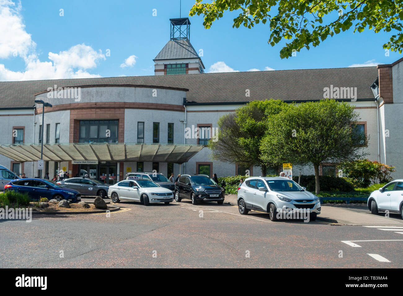 Der Haupteingang Wishaw General Hospital, ein NHS-Krankenhaus in North Lanarkshire, Schottland, mit Autos und Taxis mit Patienten und Besucher. Stockfoto