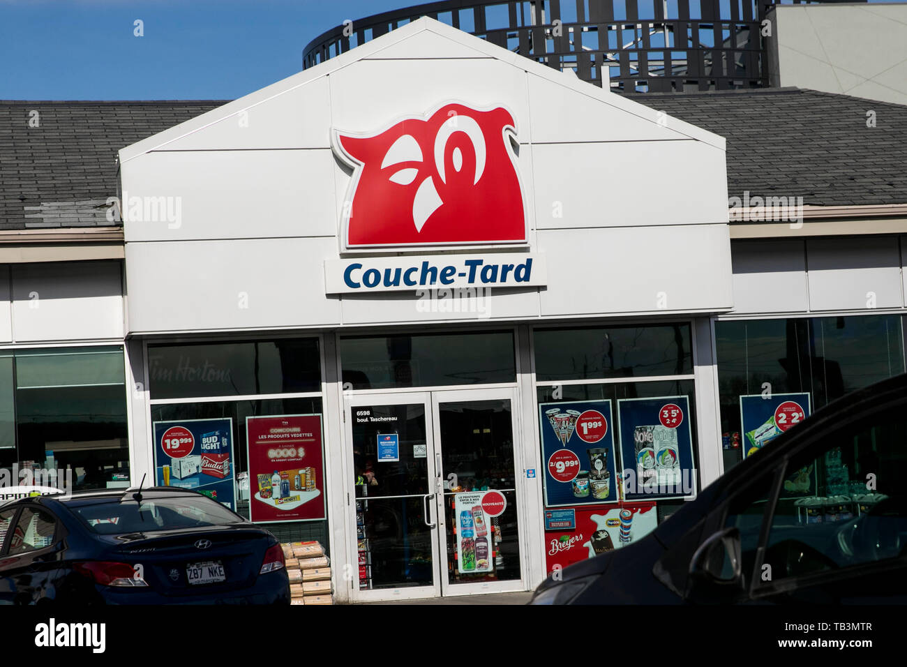 Ein logo Zeichen außerhalb eines Couche-Tard Convenience store Lage in Brossard, Quebec, Kanada, am 23. April 2019. Stockfoto