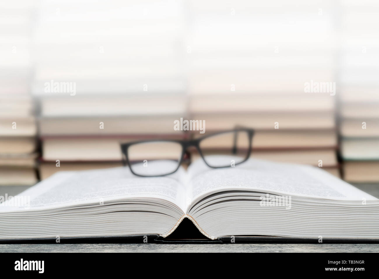 Gläser auf dem Hintergrund der Bücher. Symbol von Wissen, Wissenschaft, Studium, Weisheit. Stockfoto