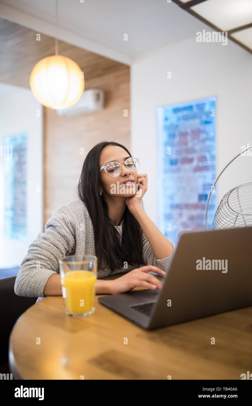 Portrait von aucasian Frau mit Laptop am Tisch in der Küche Innenraum beim Frühstück zu Hause Stockfoto