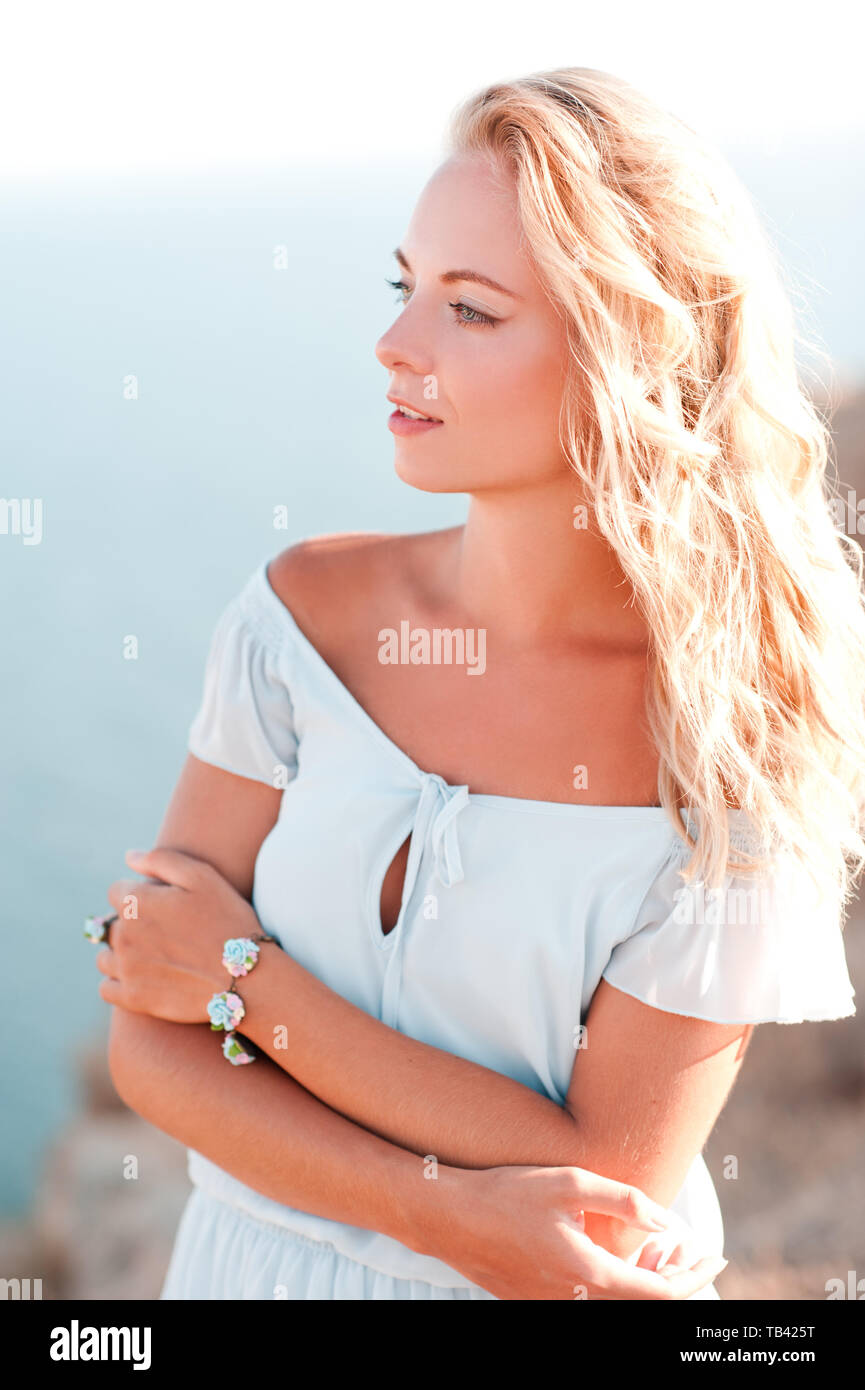 Junge blonde Frau Sommer Kleid posiert im Freien über Meer Hintergrund. 20. Stockfoto