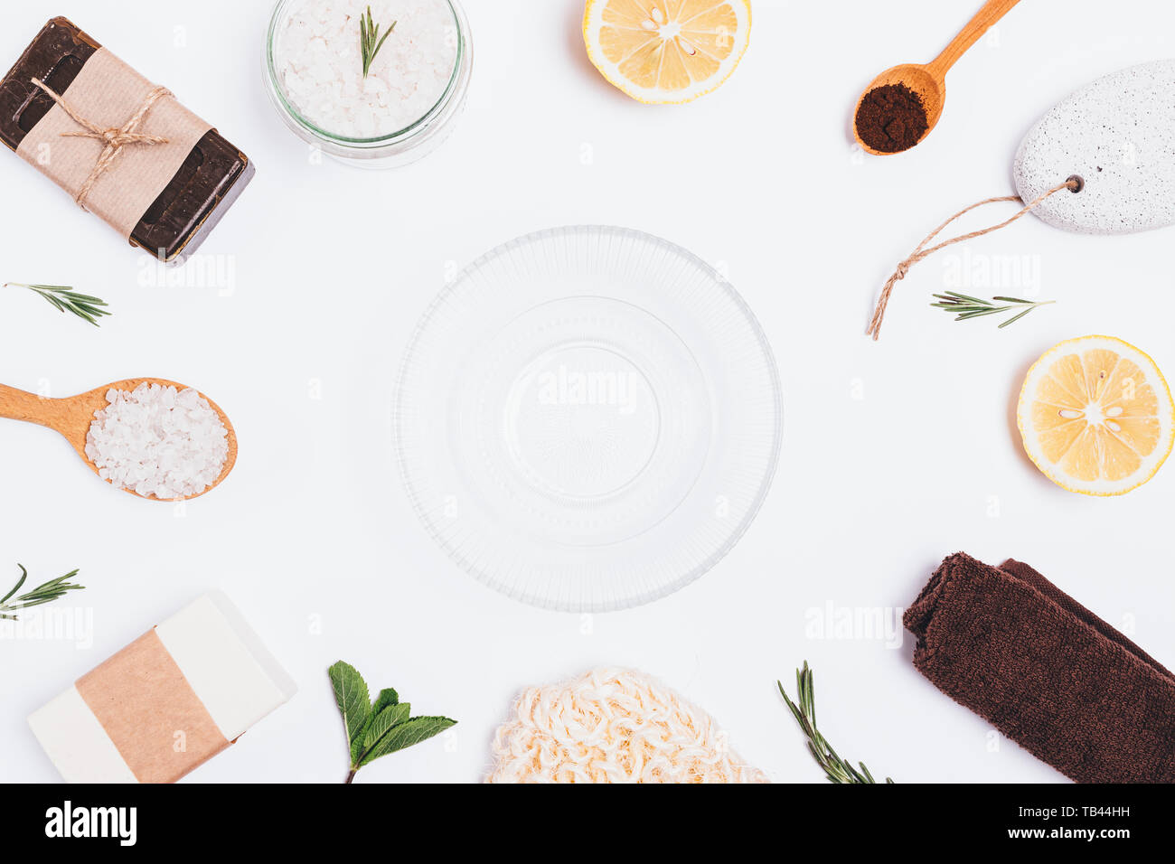 Flach Anordnung von leeren Glas Schüssel neben Zutaten für selbstgemachte Badewanne Body Scrub von Kaffee, Meersalz, Rosmarin, Minze und frischen Zitronen auf weißem Stockfoto