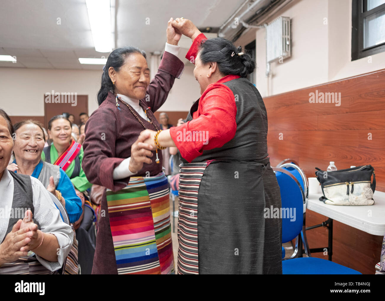 Asiatische Frauen, aus Nepal und Tibet, Tanz in den Gängen, bei einem Konzert von Himalayan Musik an der Sherpa buddhistischen Tempel in Queens, New York City. Stockfoto