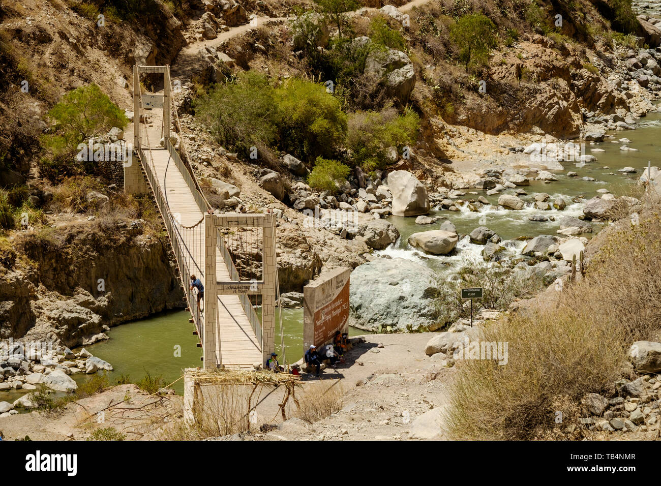 Wanderer, die sich auf der Spur neben der Hängebrücke den Colca Fluss an der Colca Canyon, Cabanaconde Bezirk, Peru zu überqueren Stockfoto