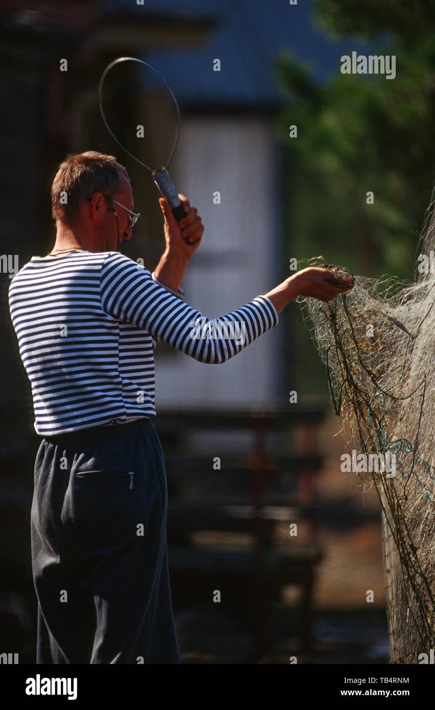 Ein Mann Reinigung Fischernetze Stockfoto