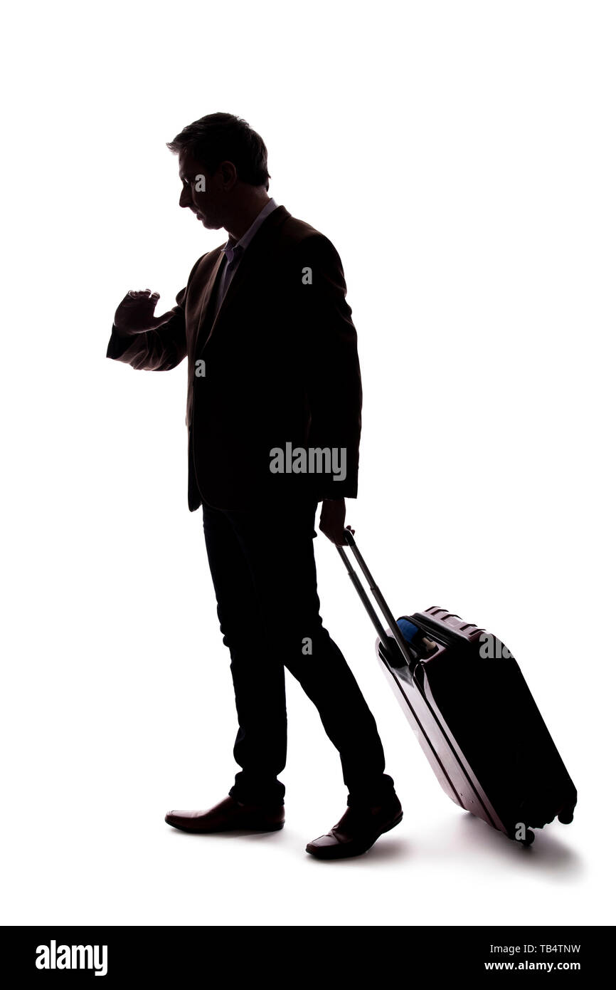 Silhouette einer reisenden Geschäftsmann auf der Suche umgekippt, weil von einer verzögerten oder Flug abgesagt. Der Reisende ist gestresst und wartet mit seinem Gepäck. Stockfoto