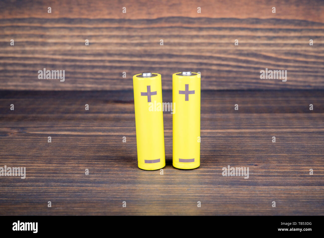 Batterien der Größe AA auf hölzernen Hintergrund Stockfoto