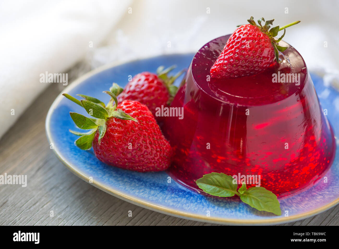 Foto von Grütze mit frischen Erdbeeren. Gesundes Essen. Erdbeer Gelee auf weiße Platte. Sommer Dessert mit Früchten Gelee und frische Erdbeeren. Stockfoto