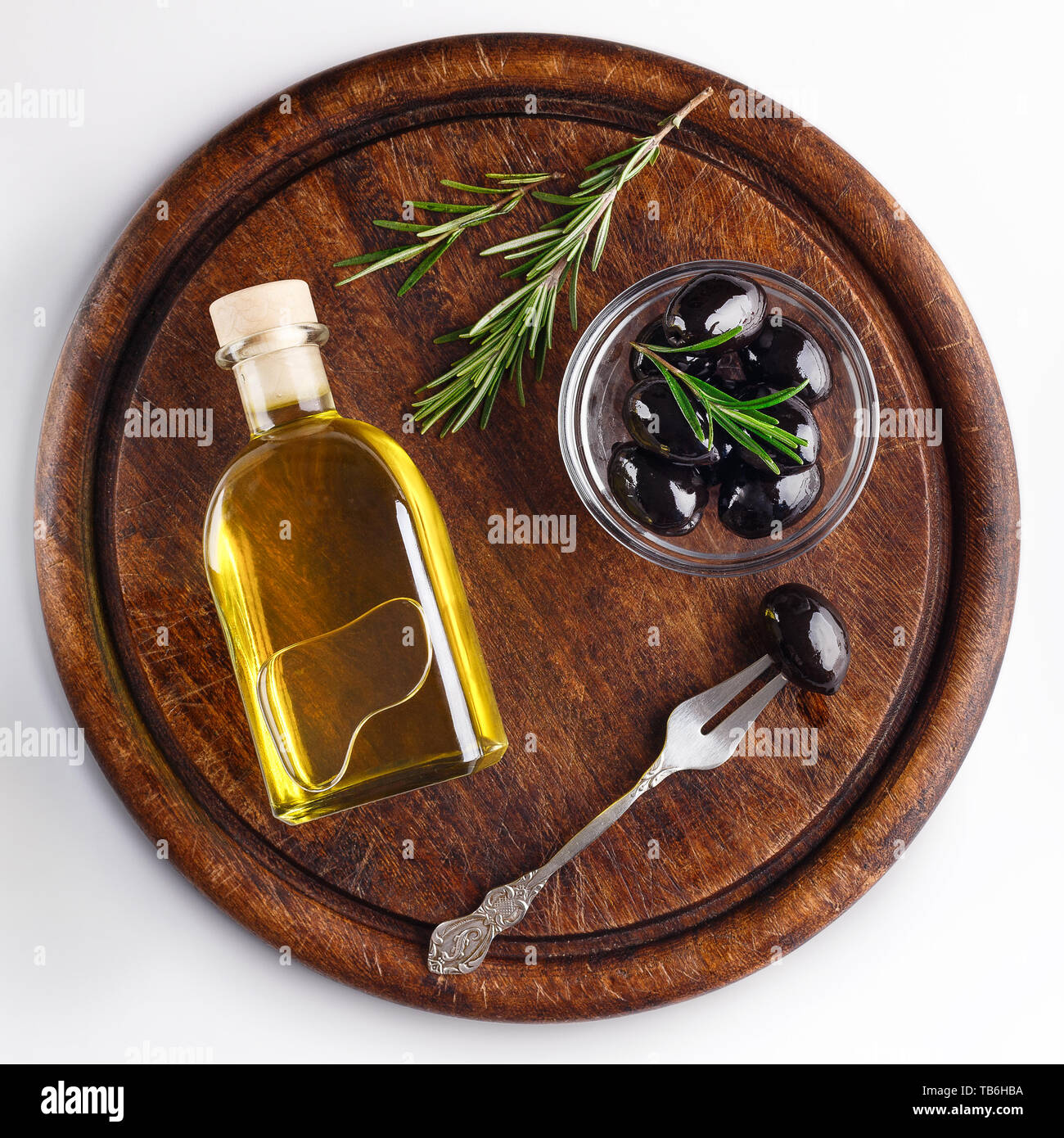 Olivenöl und schwarzen Oliven in Schale auf Holzbrett mit weißem Hintergrund, Ansicht von oben. Griechische Vorspeisen Konzept Stockfoto