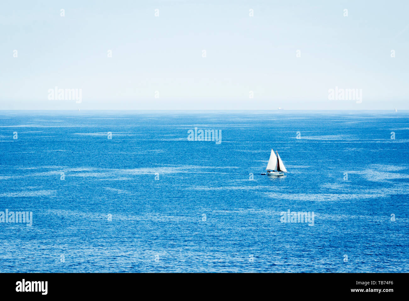Foto Meer Landschaft mit einem ​White Segelboot. Segelboot auf dem Ozean. Blaue Landschaft. Stockfoto