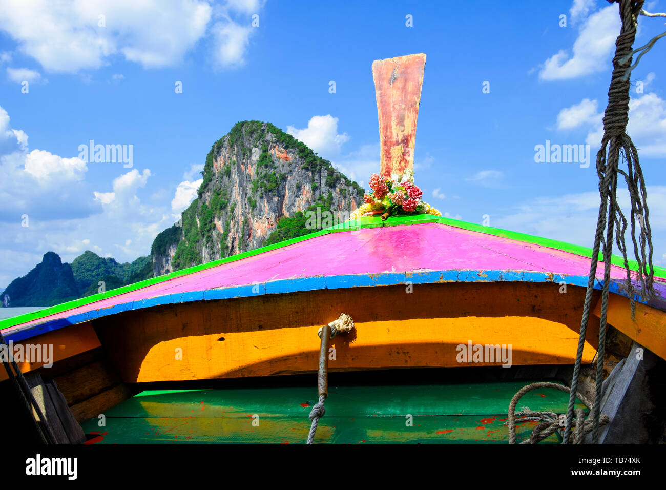 An Bord Ansicht mit der fron Teil eines hölzernen traditionellen bunten Thai Boot segeln in der Andaman Sea, Thailand. Im Hintergrund hohen Berg zu b Stockfoto