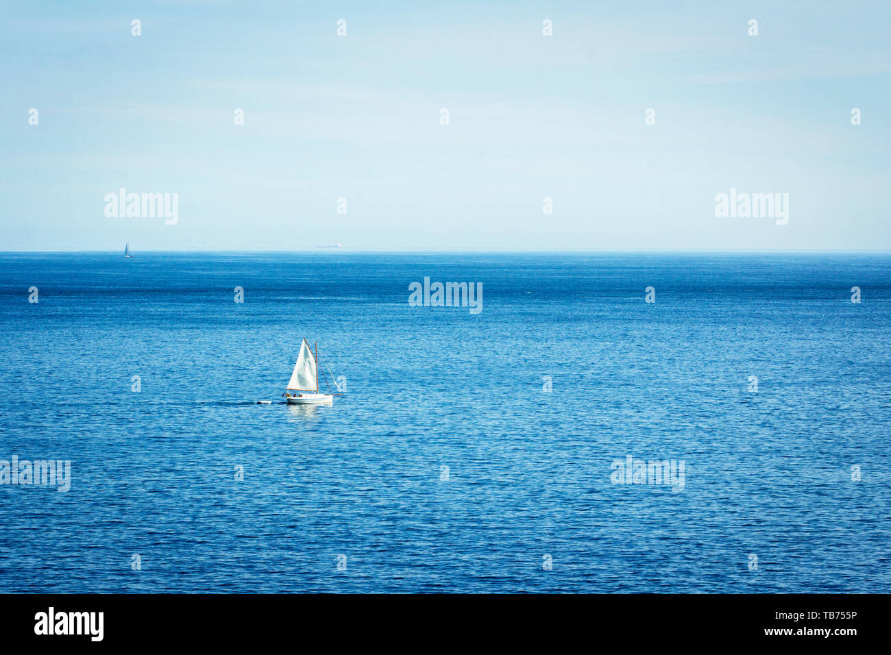 Foto Meer Landschaft mit einem ​White Segelboot. Segelboot auf dem Ozean. Blaue Landschaft. Stockfoto