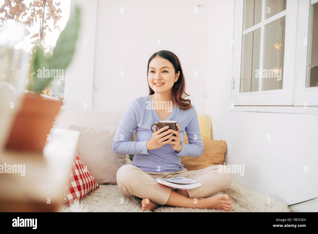 Schöne junge Frau entspannende und zur Festlegung auf eine äußere Bett auf einem Haus Terrasse Garten und Lesen von Zeitschriften im Urlaub Stockfoto