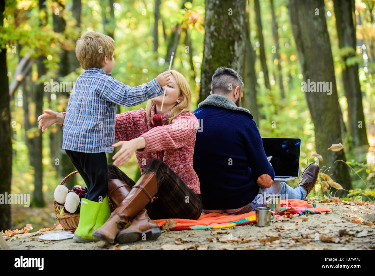 Konflikte, Vati. Familie und Beruf zielen. Vati ist immer besetzt. Tag der Familie Konzept. Familie mit Kind Junge Entspannung in wald. Mutter und wenig spielen zusammen, während der Vater arbeiten mit Laptop. Stockfoto
