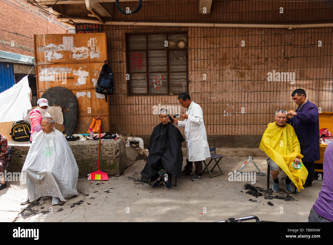 28. Juli 2018, Kunming, China - Friseur- Kunden auf der Straße Stockfoto