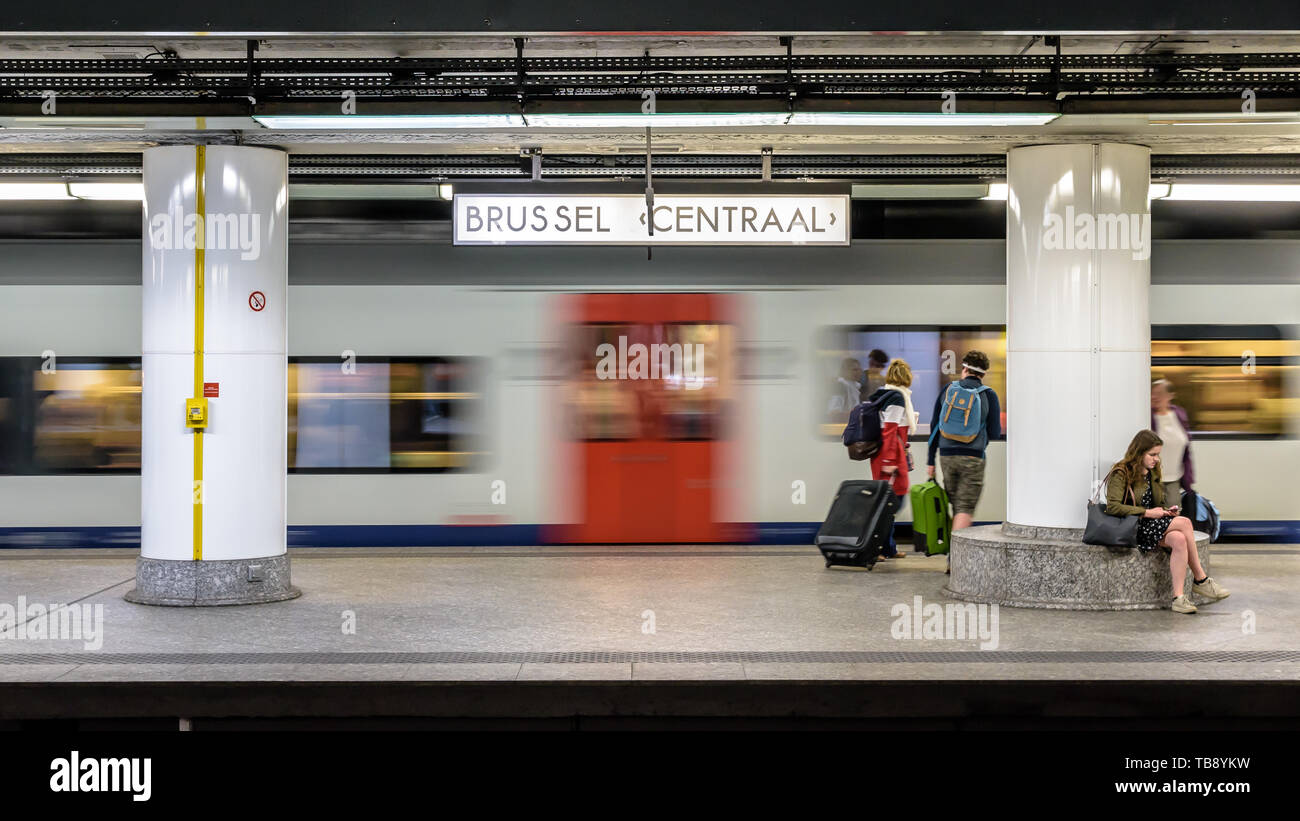 Passagiere mit Koffer warten auf eine U-Plattform in Brüssel Hauptbahnhof als InterCity Zug geht. Stockfoto