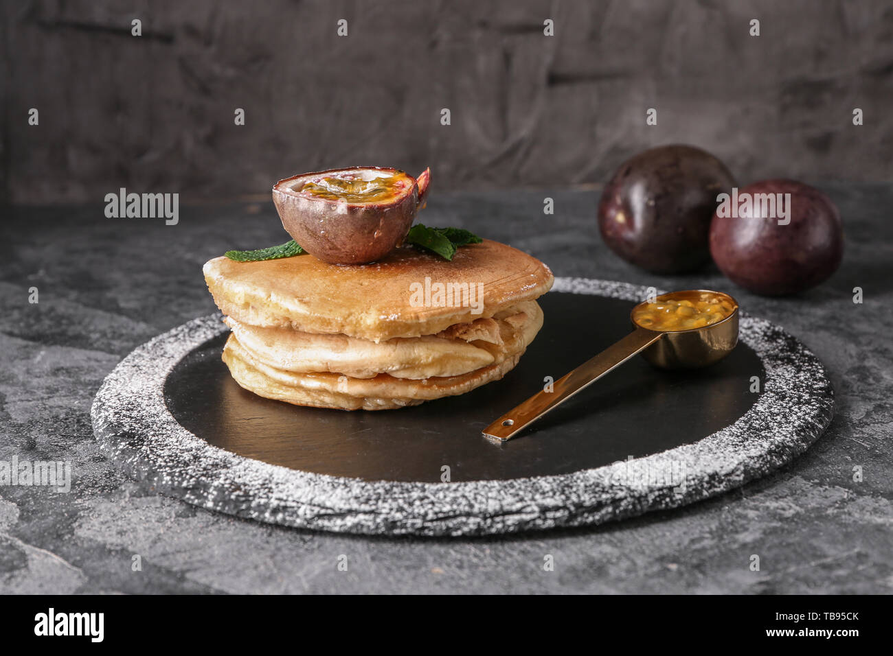 Leckere Pfannkuchen mit Passionsfrucht auf schiefer Platte Stockfoto