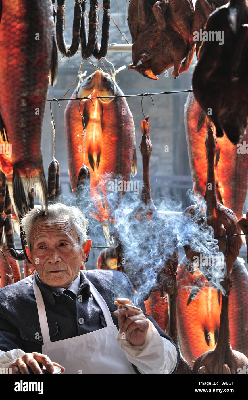 Lunyue, die jetzt nur noch in der Lu Xun Romane gesehen, ist vollständig in Anchang erhalten. In Anchang, den alten Markt am Fluss ist voller Fische, getrocknet, Salami, Sauce Ente und Lu Xun Romane. Halb-menschlichen grün Fisch hängen unter dem Dachvorsprung, die Sonne durch die Fisch trocknet die freudige Rot; hausgemachte hausgemachte Wurst und Soße Ente, natürlich trocken, dicke Sauce Geschmack durchdringt den gesamten Markt. Der alte Mann machte eine nette Tasse Tee am Nachmittag Sonne und machte ein Nickerchen. Ich gab eine Zigarette und lauschten der alte Mann erzählt die Geschichte über die volkstümlichen Bräuche von Anchang. Stockfoto