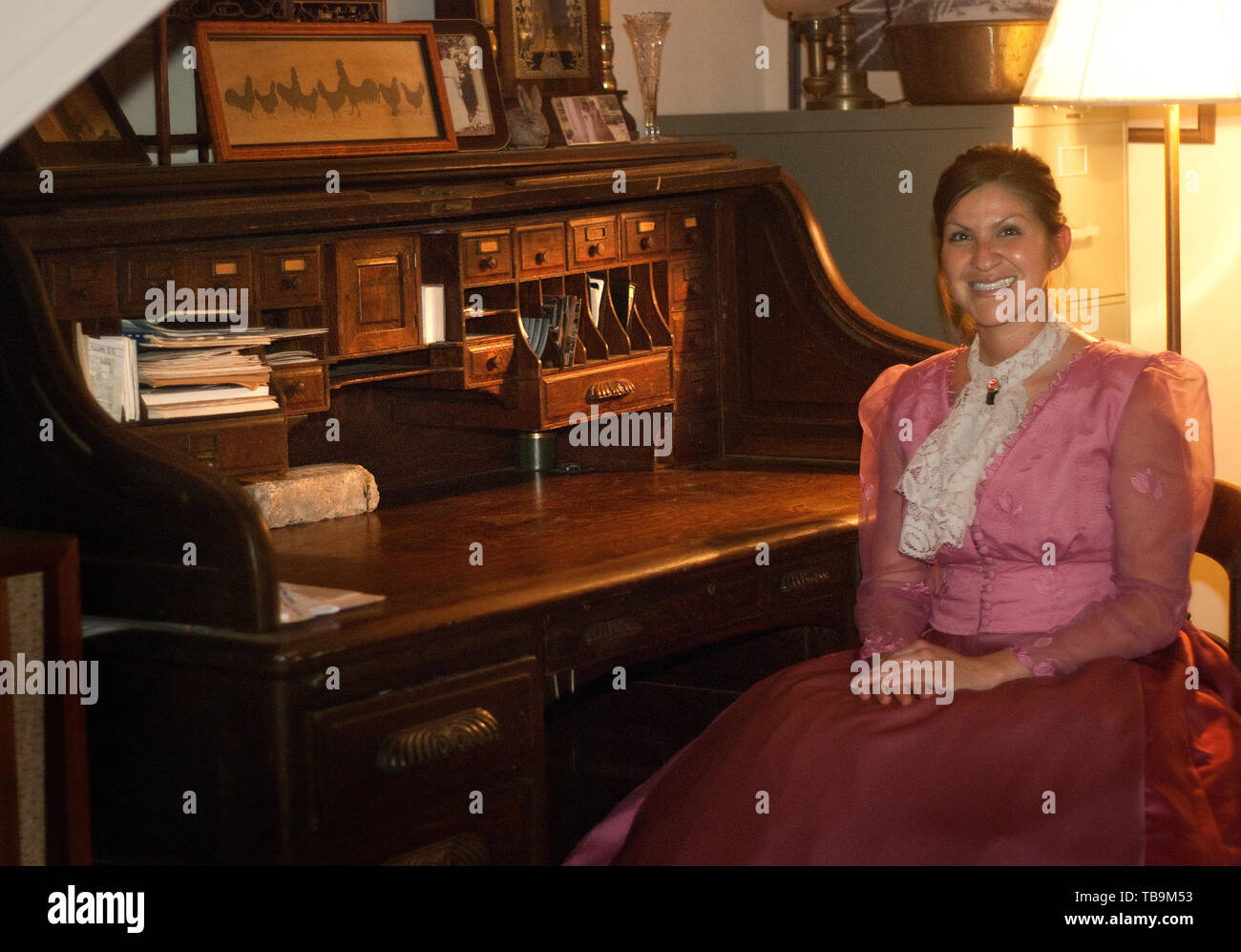 Eine Frau sitzt auf einem antiken rolltop Schreibtisch im Riverview, ein historisches Haus in Columbus, Mississippi. Stockfoto