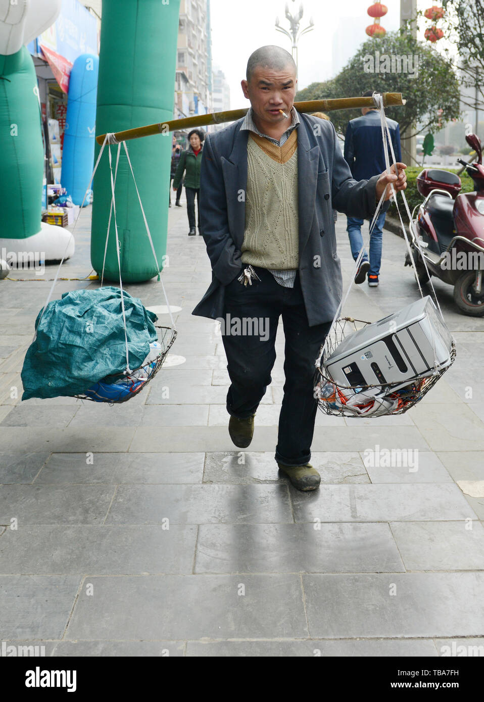 Ein chinesischer Mann die Körbe mit alten Computern in den Straßen von Kaili. Stockfoto